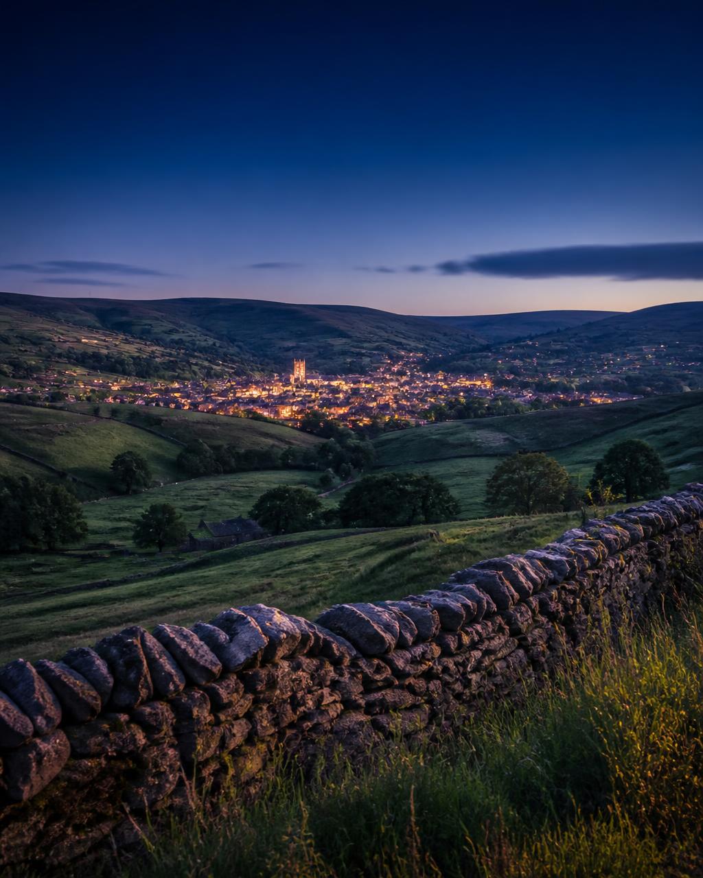 Yorkshire Dales at dusk with a warm market town in the valley, representing rooted local business growth
